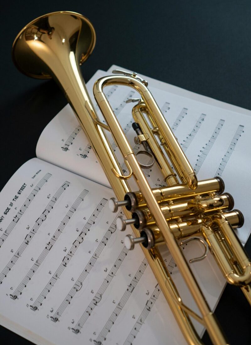 A golden trumpet resting on sheet music, perfect for music themes.
